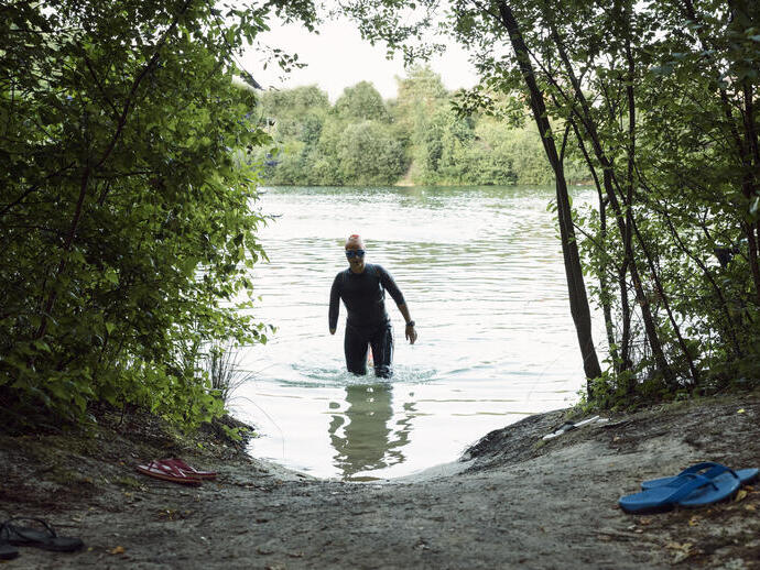 Woman in a wetsuit walking through water