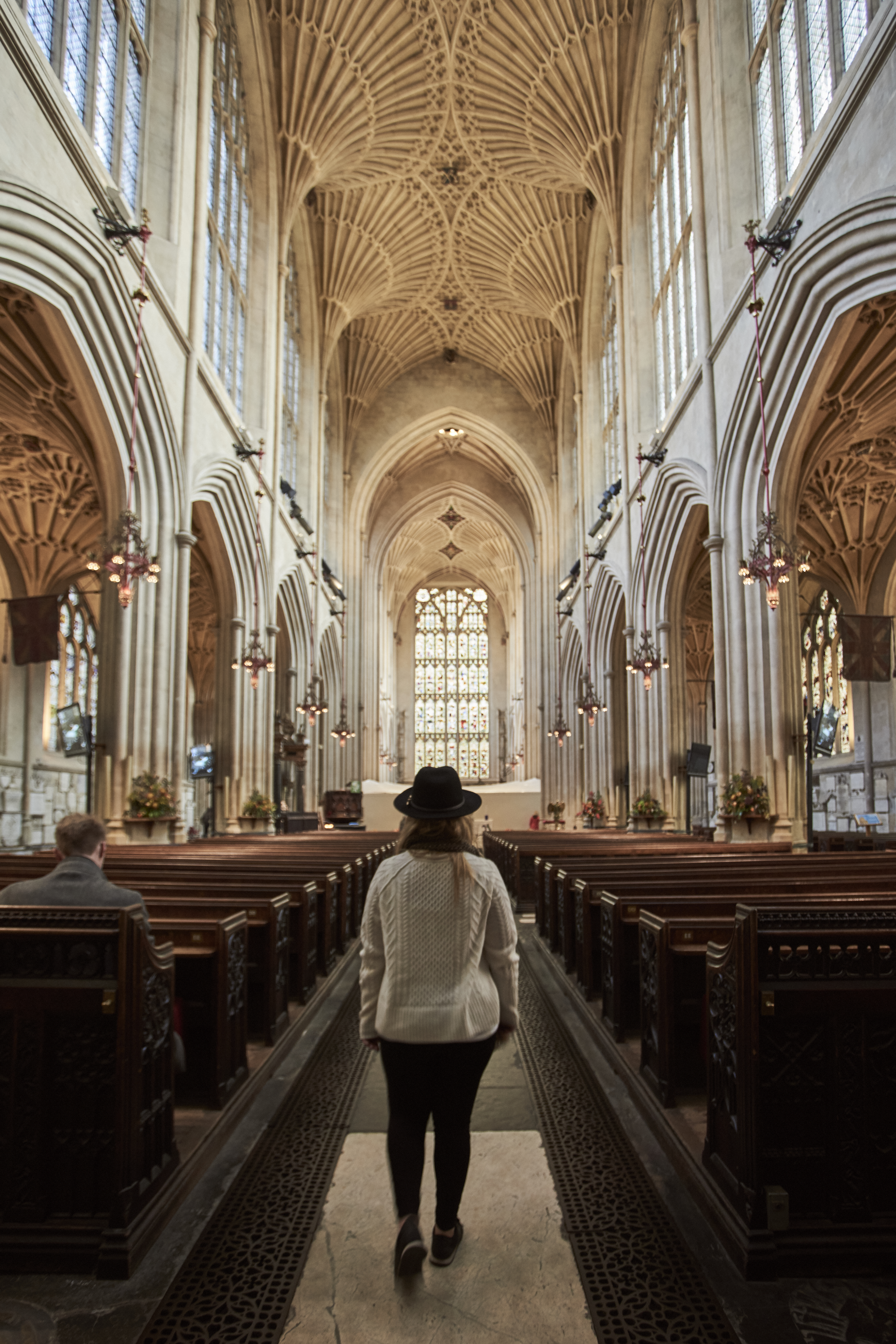 Woman walking down the aisle of an abbey