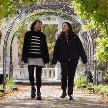 Two women walking through gardens