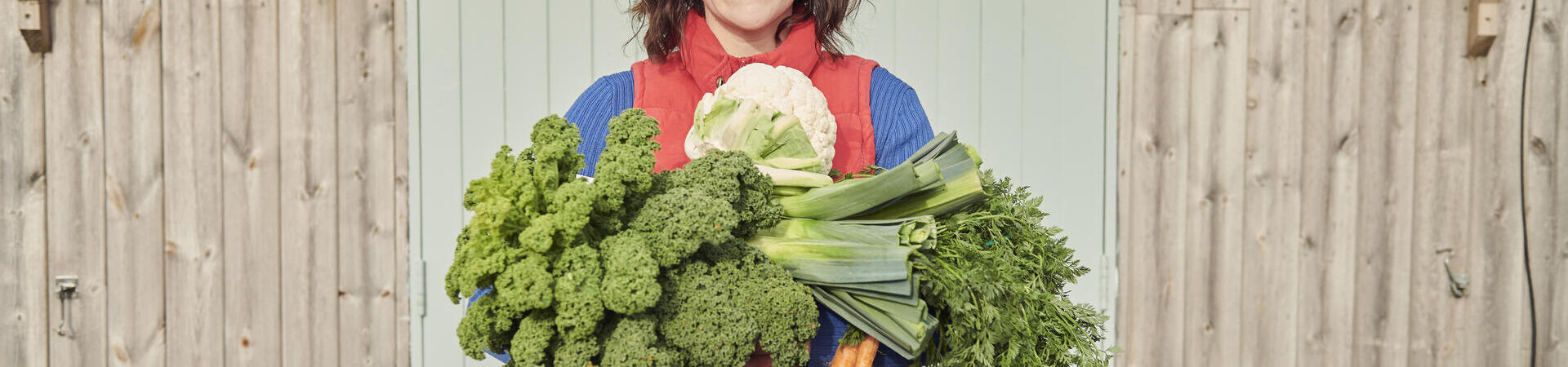Woman holding a selection of fresh vegetables