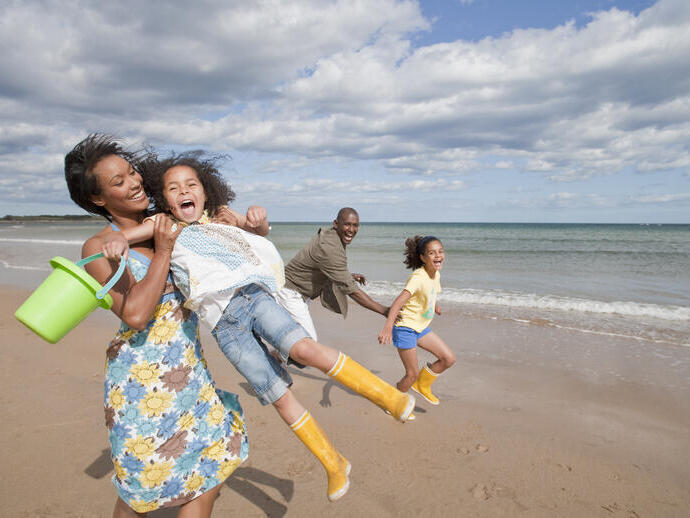 Familia jugando en la playa bajo el sol