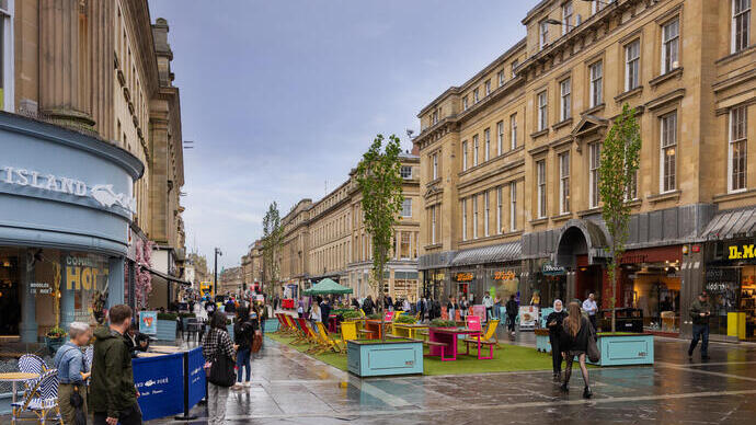 People in a busy street with shops and cafes
