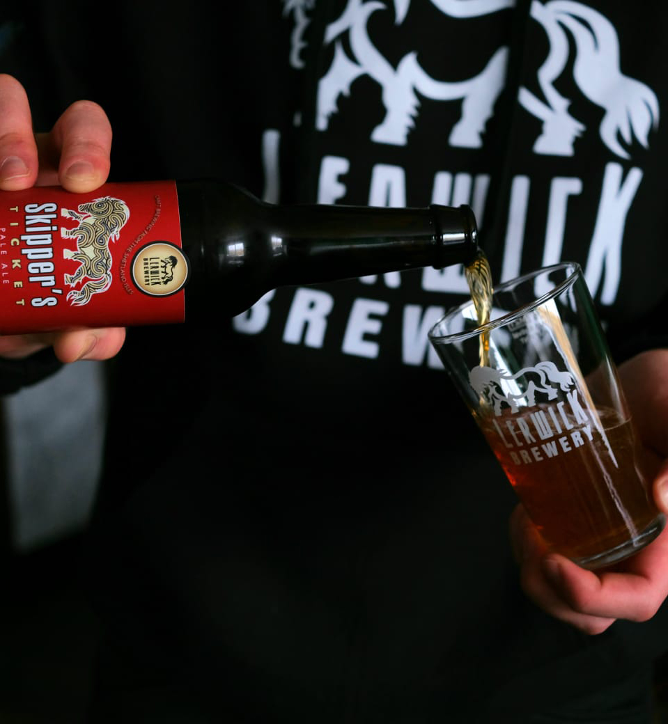 A man pouring beer into a glass at Lerwick Brewery