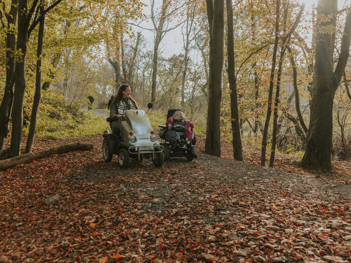 Deux femmes utilisant des scooters électriques dans une forêt
