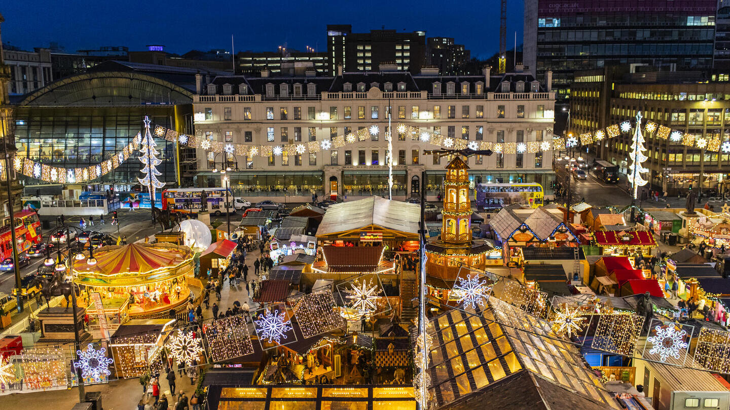 Aerial view of Christmas market and funfair lit up at night
