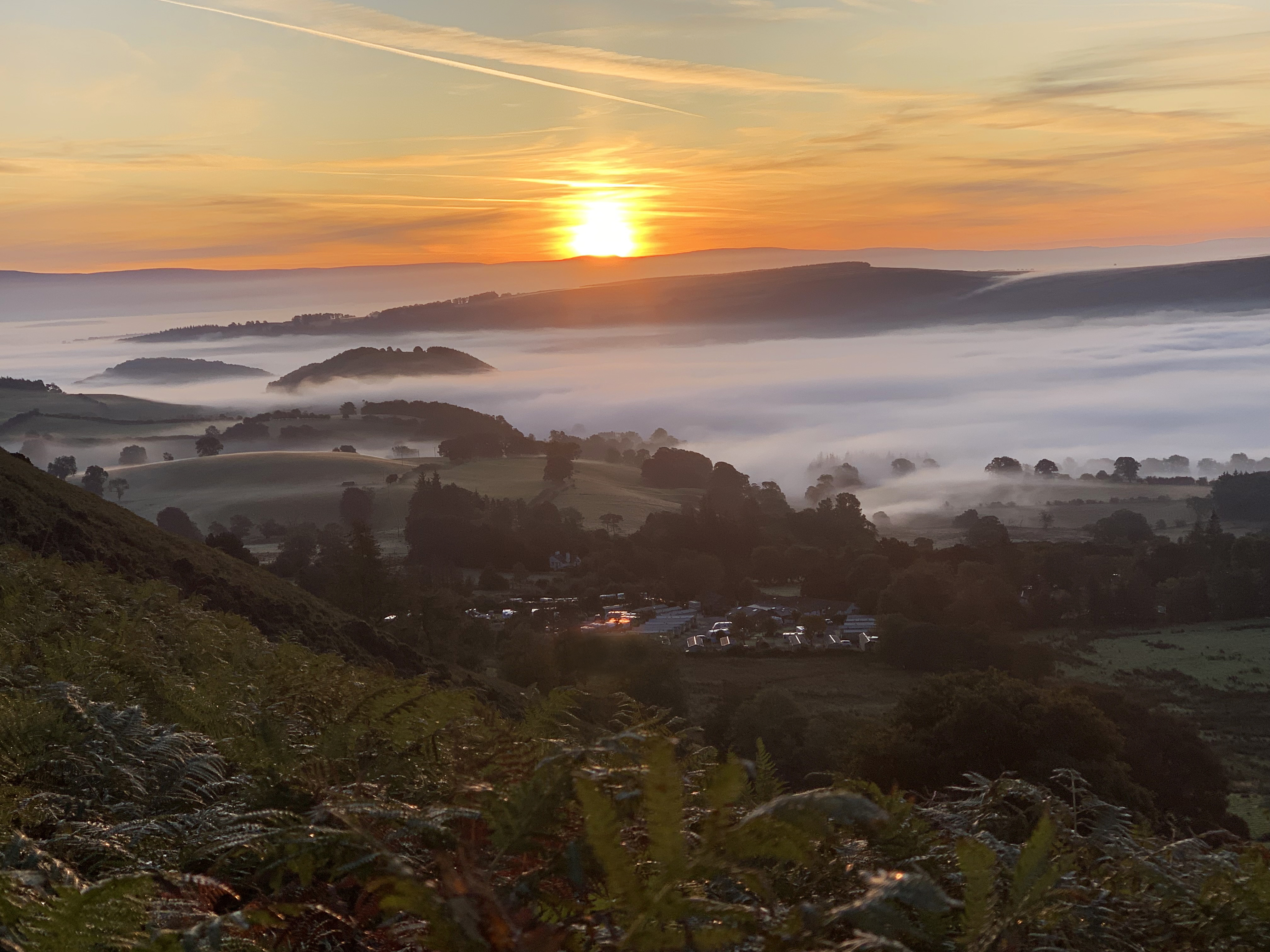 Zonsopgang en mist boven een camping op het platteland.