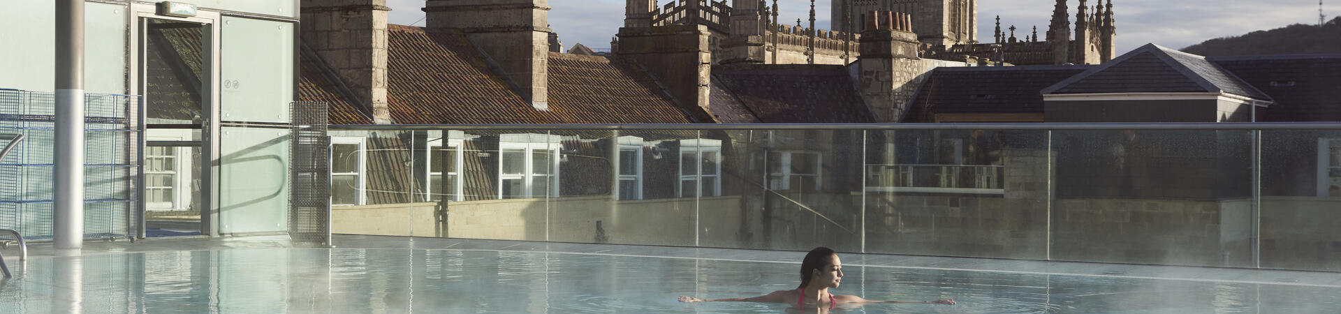 Woman in a roof top swimming pool at a spa