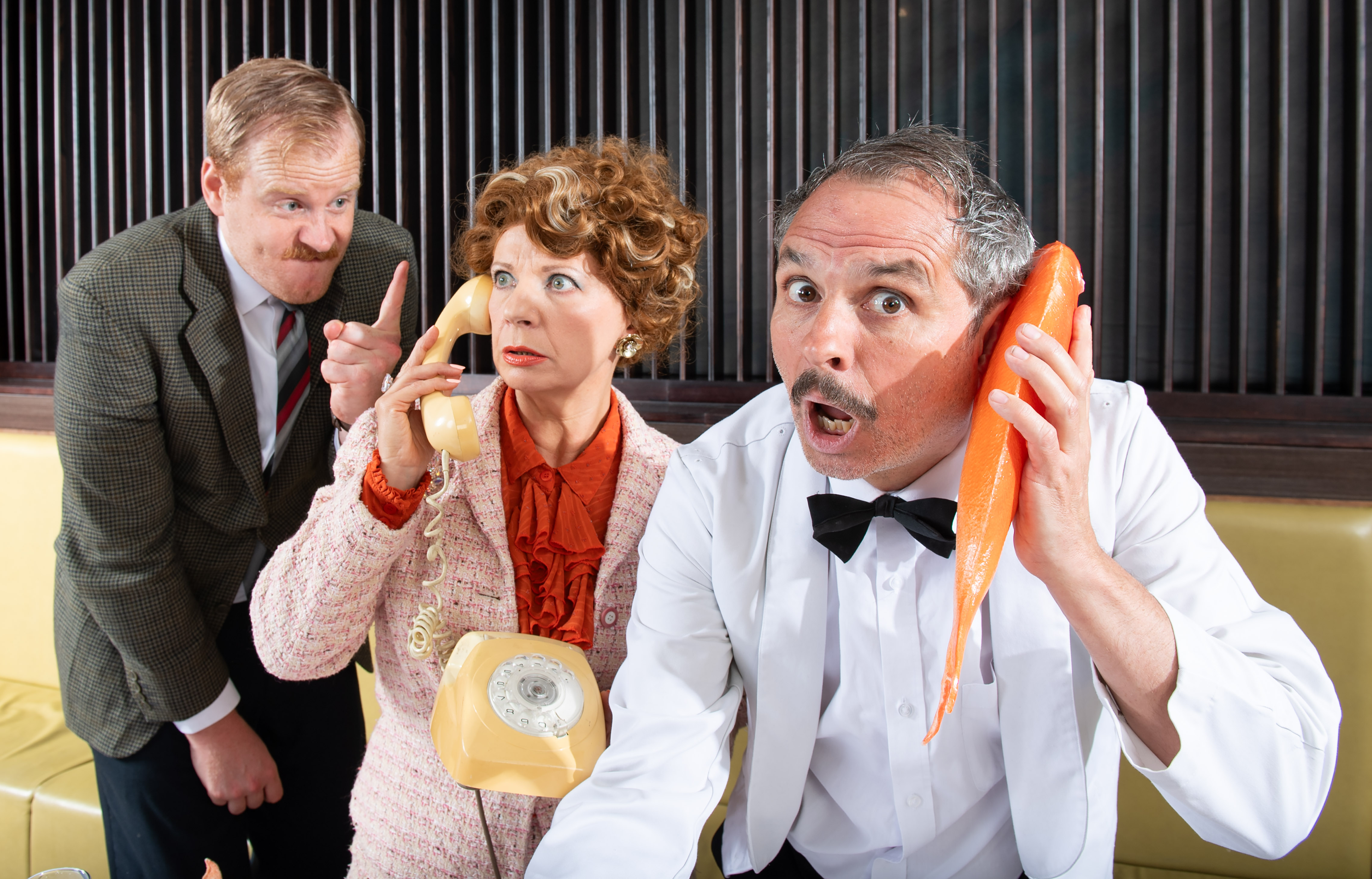 Actors in costume on the set of a farcical play.