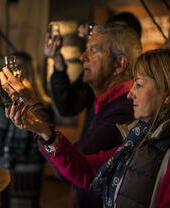 Grupo de personas observando vasos de whisky en la destilería Talisker