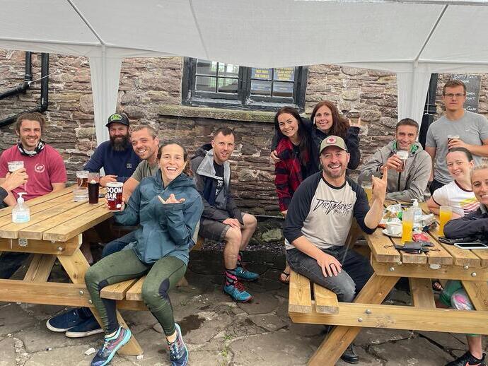 A group of hikers and people sat on tables outside The Skirrid Mountain Inn in Avergavenny, Wales
