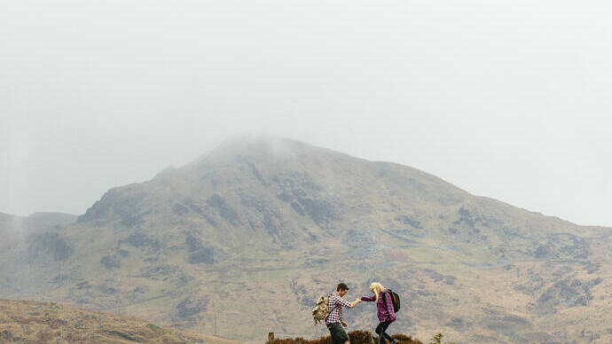 زوجان يتنزهان في الجبال في يوم غائم