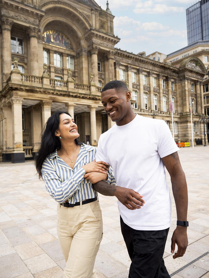 A woman and a man walk through a town square