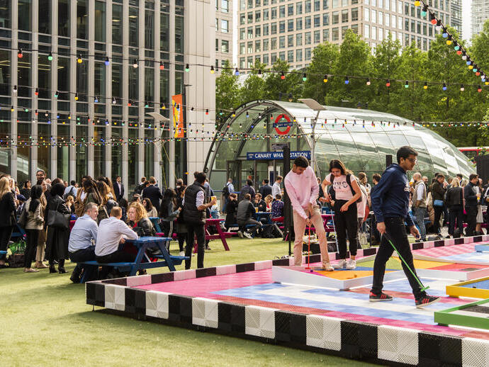 Menschen, die auf dem Nachtmarkt in Canary Wharf Minigolf spielen