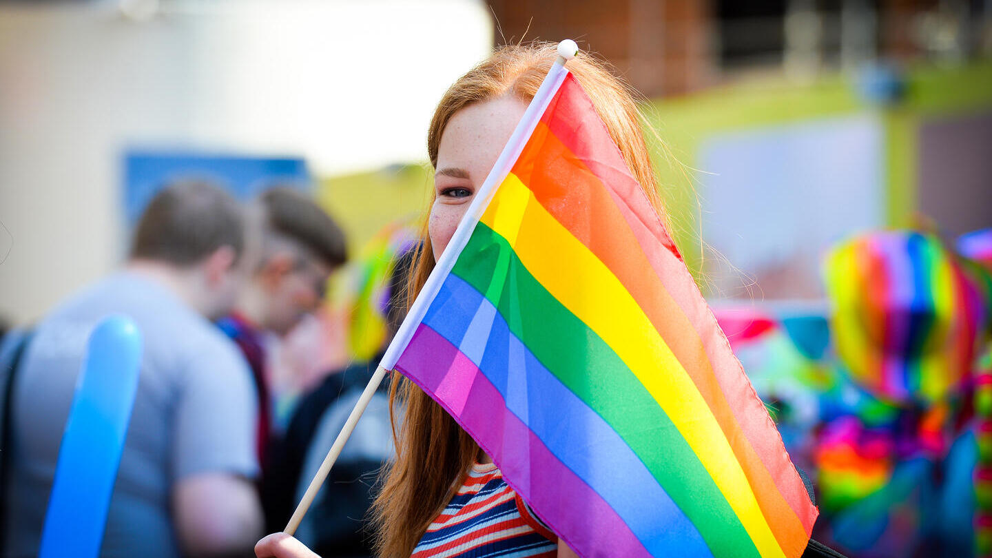 Une personne brandissant un drapeau arc-en-ciel lors de la Leicester Pride