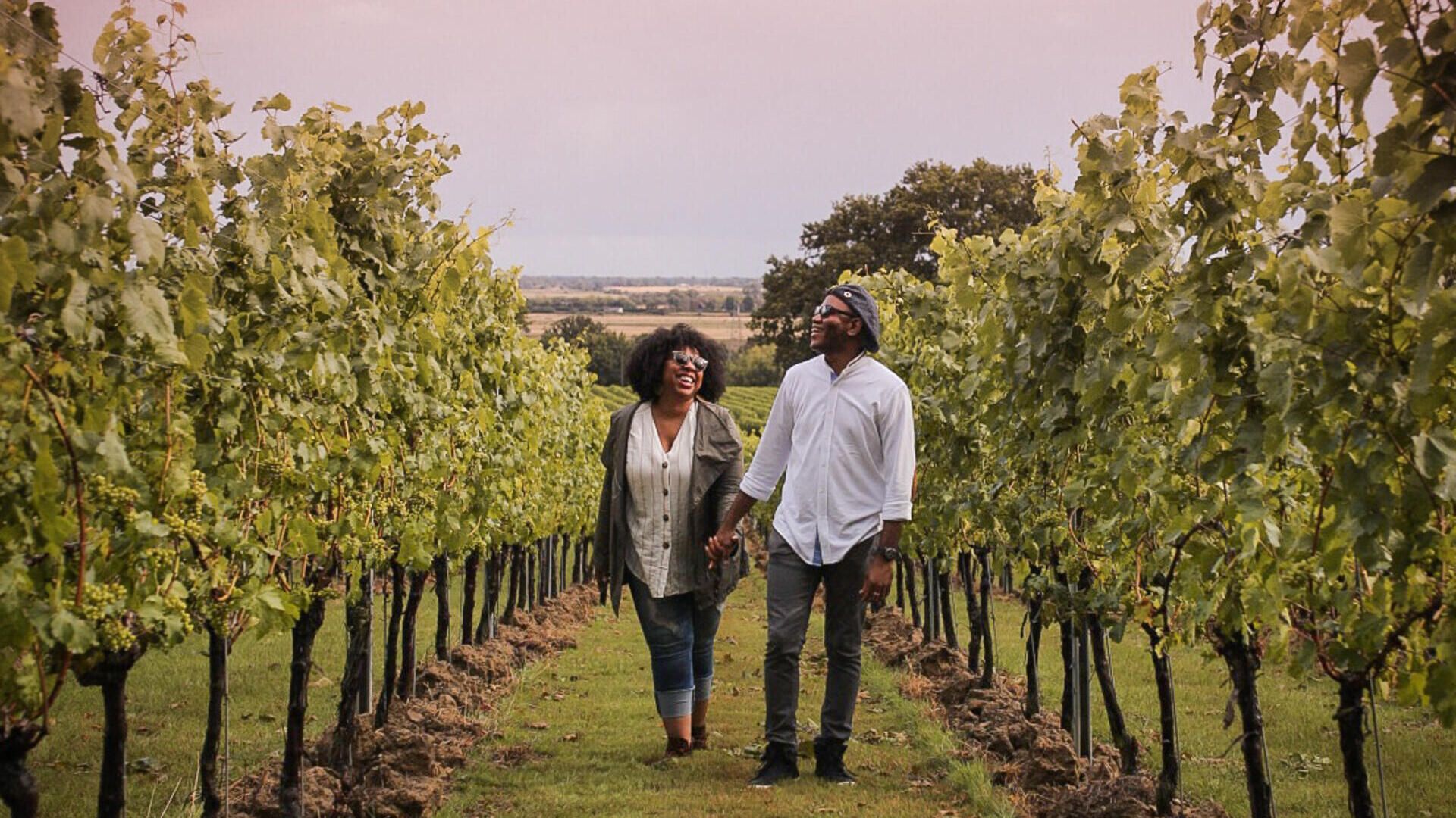 Man and woman walking between rows of vines at a vineyard