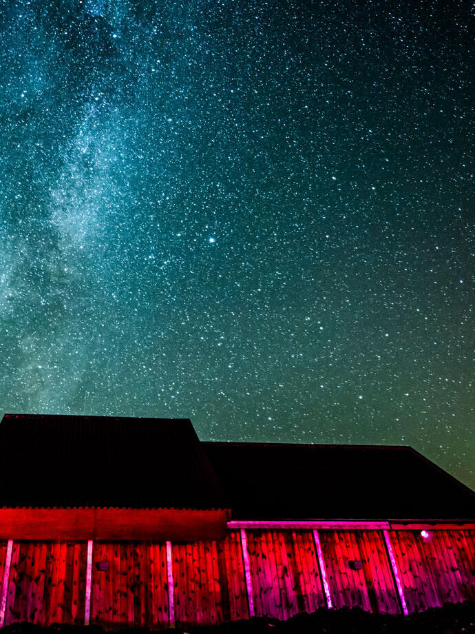 A dark sky observatory lit up at night under the sky.