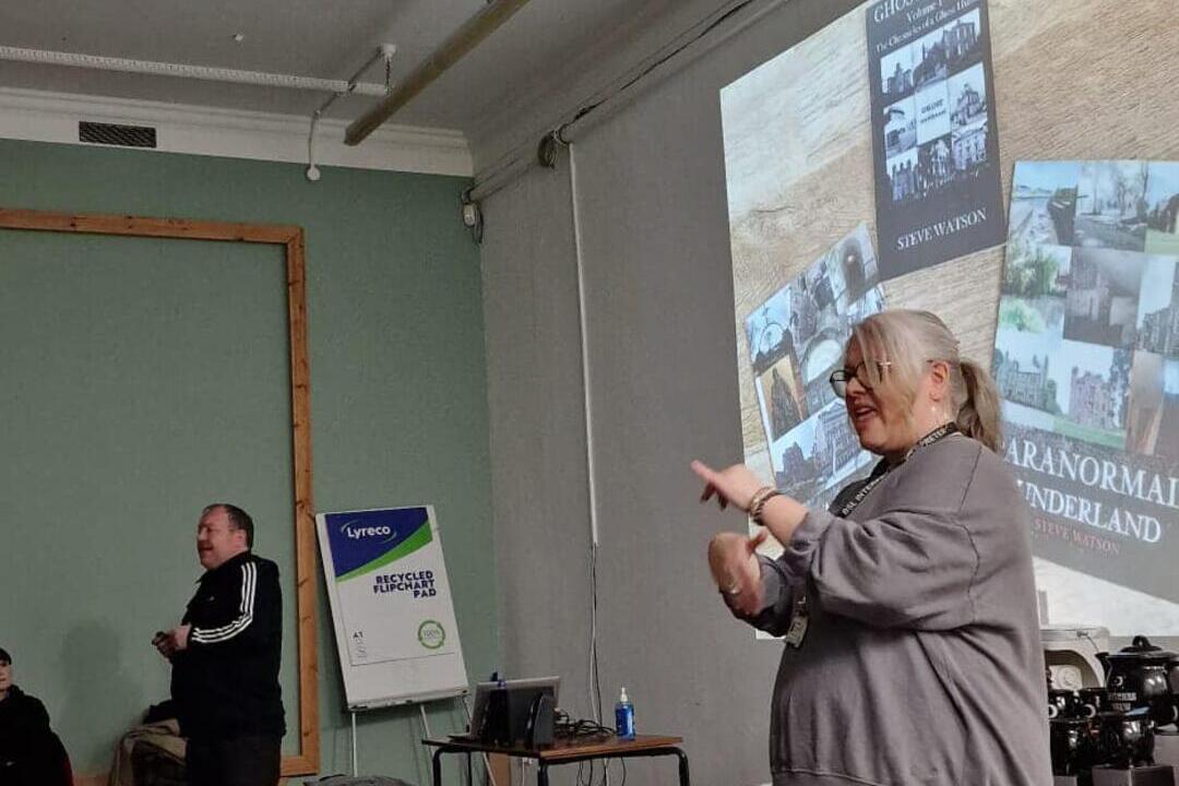 Woman doing a presentation with sign language in front of audience