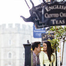 Couple in a street near tea shops and a castle in the background