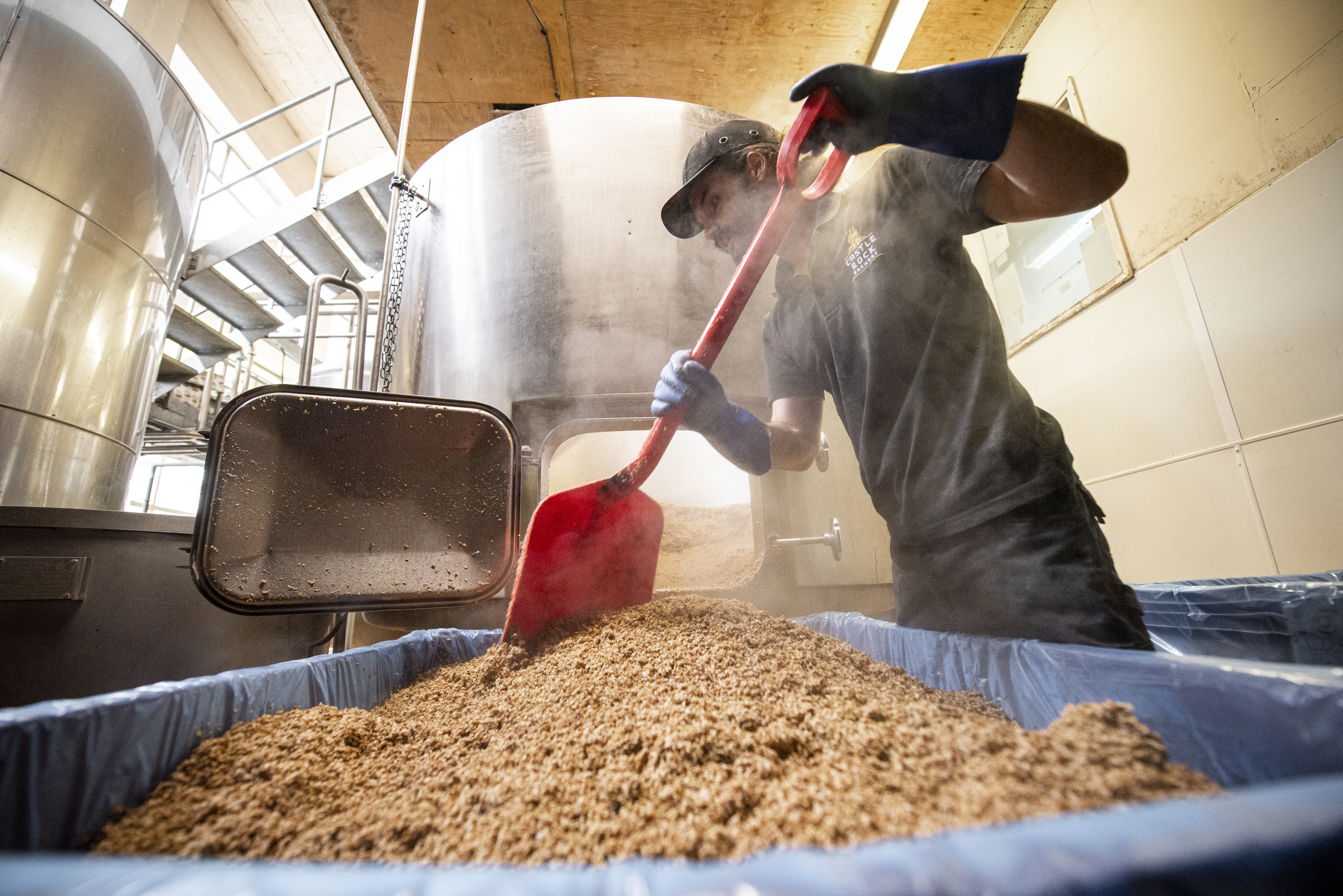 Hombre trabajando en la producción de cerveza en una fábrica