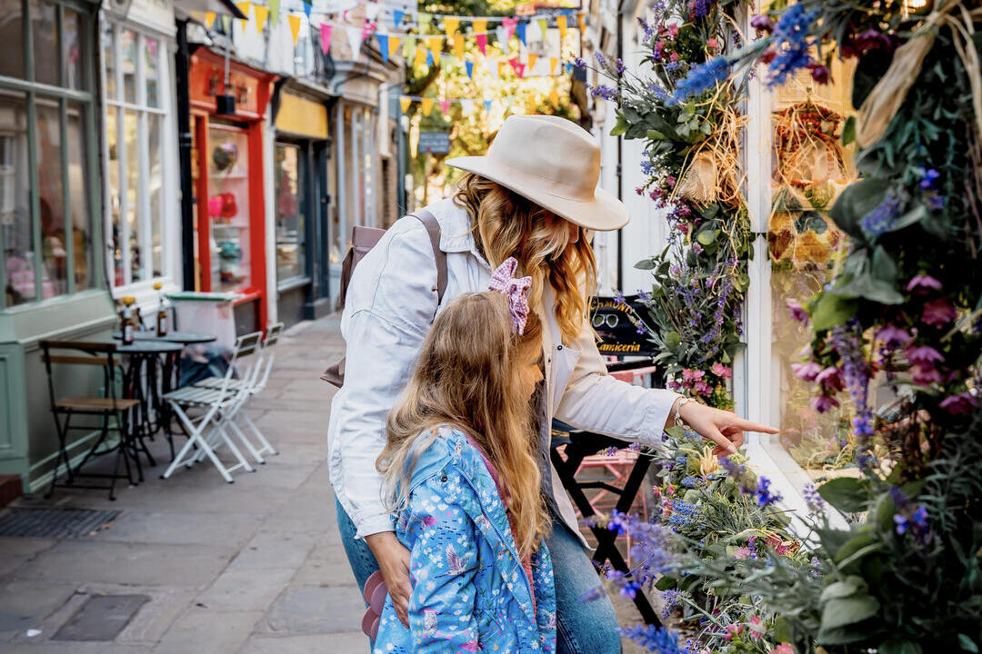 Eine Frau und ein Kind schauen in ein Schaufenster in einer Fußgängerzone