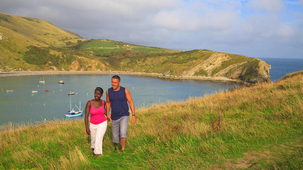 Un couple marchant au sommet d'une falaise.