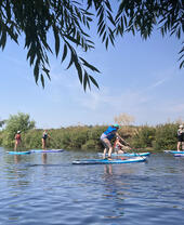 Un grupo de personas practicando paddle surf por el río Avon, cerca de Stratford-upon-Avon