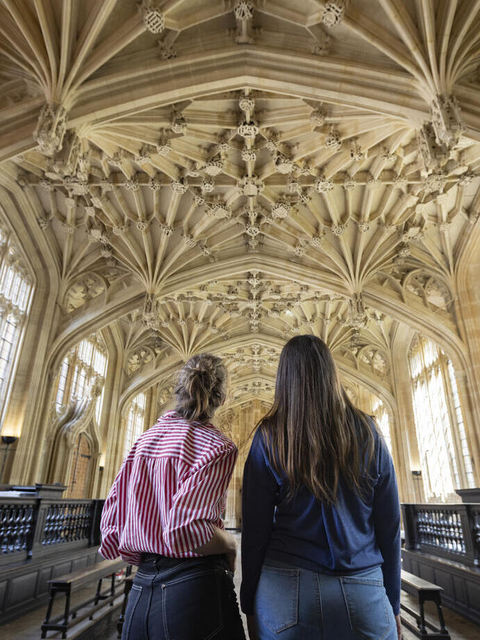 Dos mujeres miran hacia un techo ornamentado