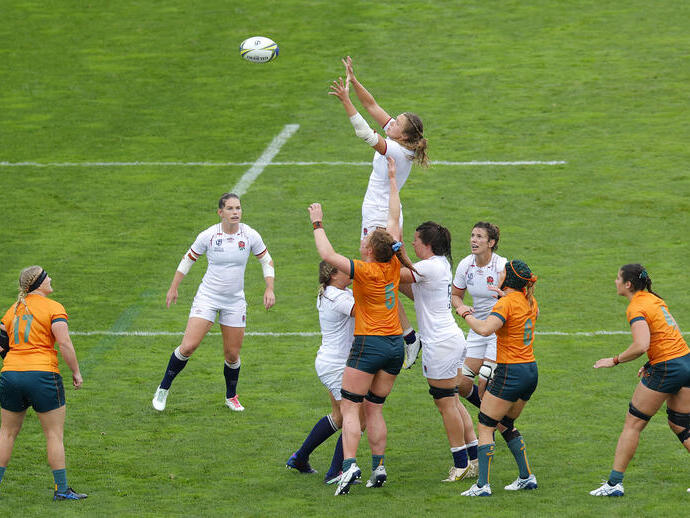 Frauen-Rugbyspiel mit Spielerinnen beider Teams, die auf dem Feld springen, um den Ball zu fangen