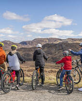 Group of people on bicycles looking at a valley