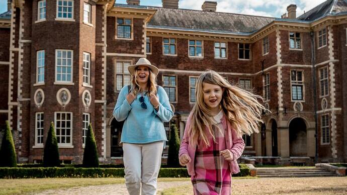Woman and child in front of a country house