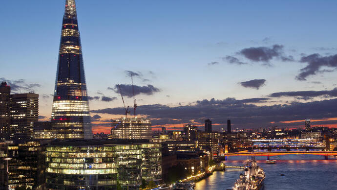 City buildings lit up at night on the banks of a river