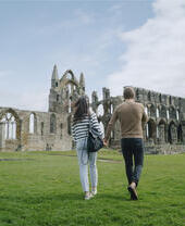 Un homme et une femme marchant vers une abbaye historique