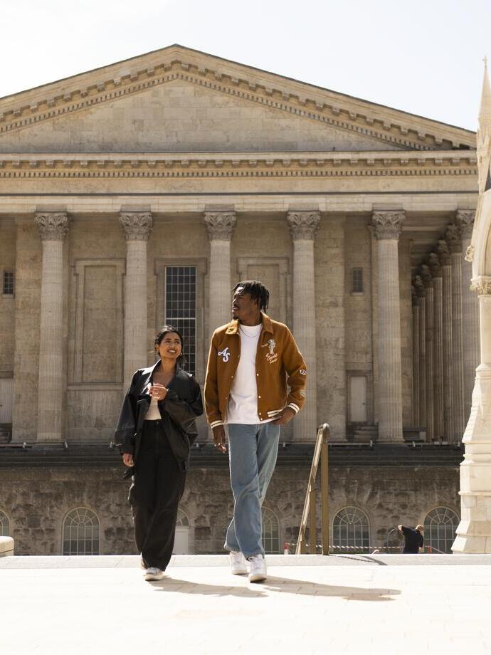 A couple strolling through an ornate English Town Square