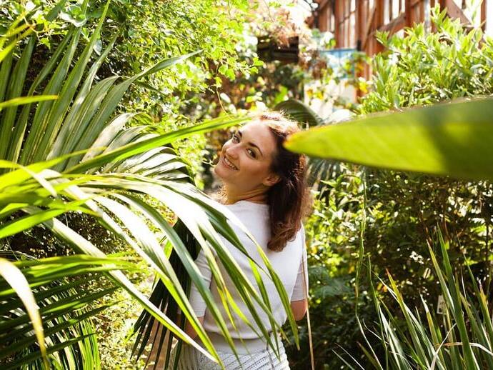 Woman smiling at camera while walking through a Botanic Garden