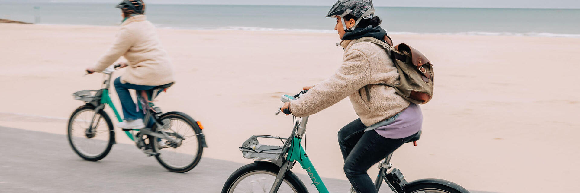 شخصان يركبان الدراجات على شاطئ بورنماوث.