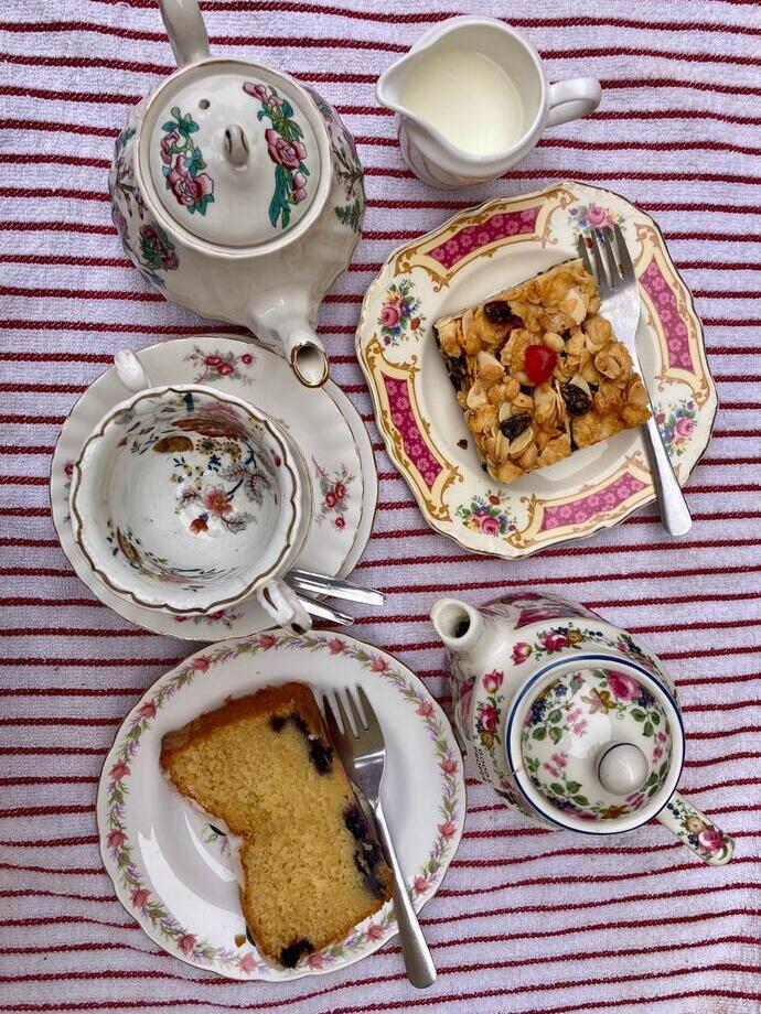 A table full of tea and cafe snacks.