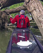 A man steering a kayak down a river in Oxford