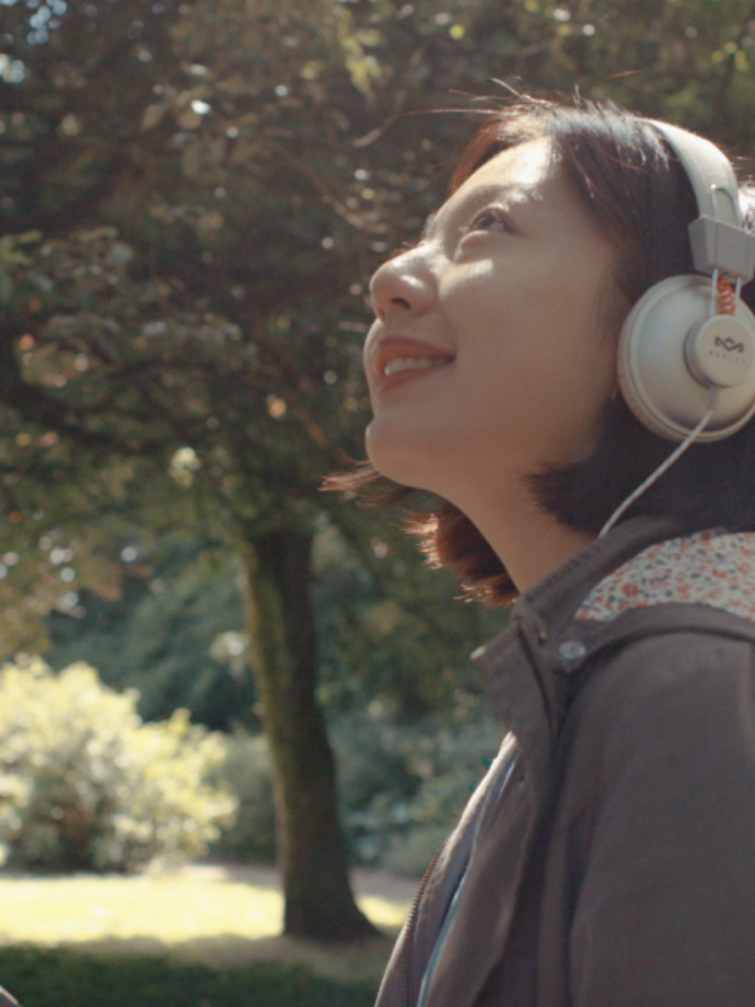 Una mujer con auriculares contemplando un jardín en el Museo Nacional de Historia de St Fagans, Cardiff