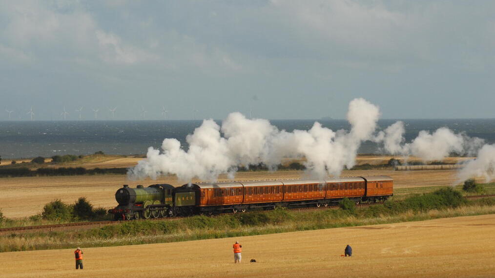 Un treno a vapore che attraversa i campi sulla costa