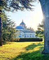 Historic mansion surrounded by trees and garden