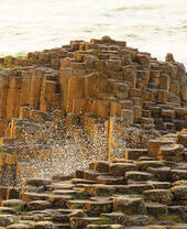 Man and child sitting on rock formations by the sea