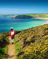 A person on a footpath on the coastal path near sea