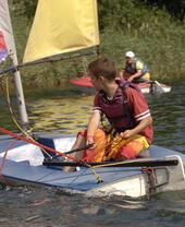 Un enfant faisant de la voile sur une rivière dans le parc national des Broads