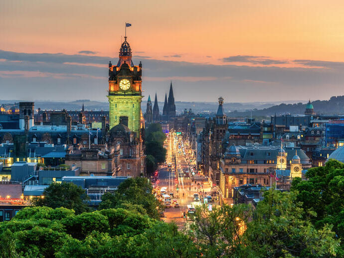 A clock tower at sunset in a busy city