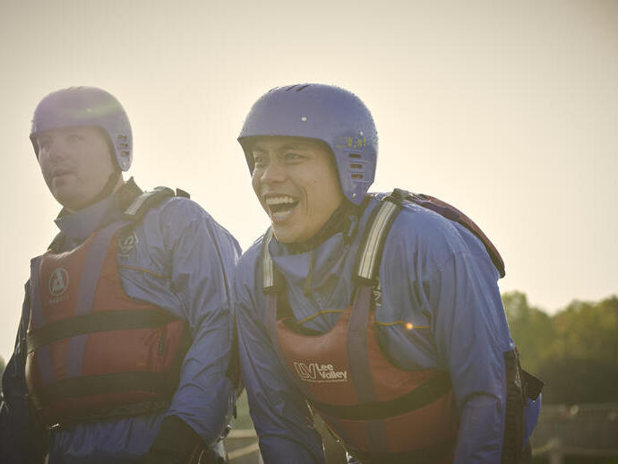 Two men wearing life jackets and helmets