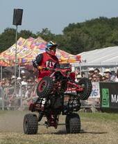 A quad bike doing a stunt in front of a crowd at the Royal Cheshire Show