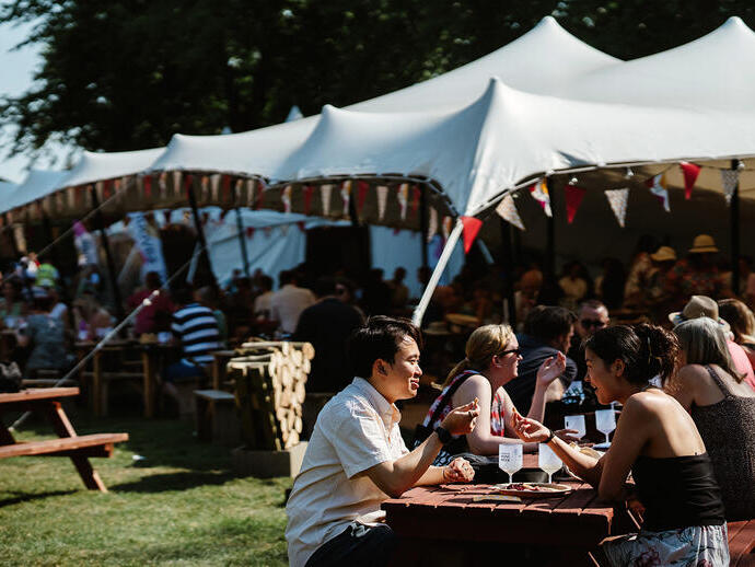 Groups of people sitting at tables and drinking wine at Norwich Wine Festival