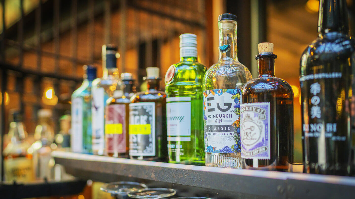 Gros plan sur une rangée de bouteilles d'alcool exposées dans un pub