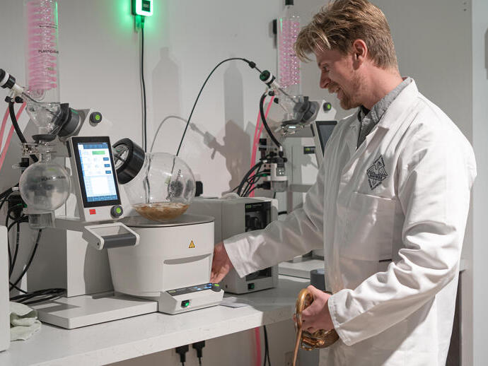 Un uomo in camice da laboratorio che utilizza una macchina per la distillazione