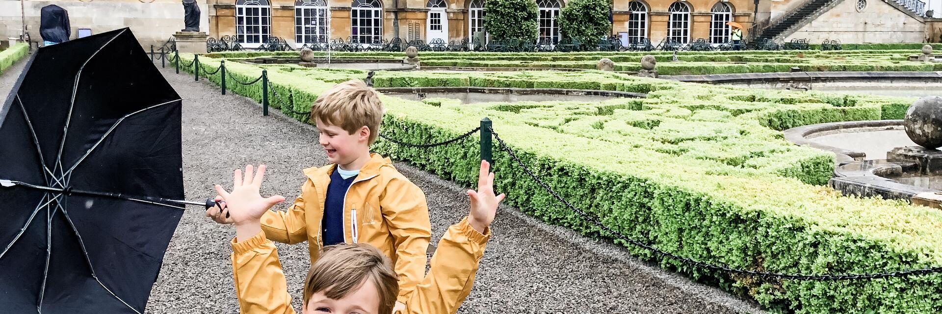 طفلان يلعبان في حديقة قصر كبير.